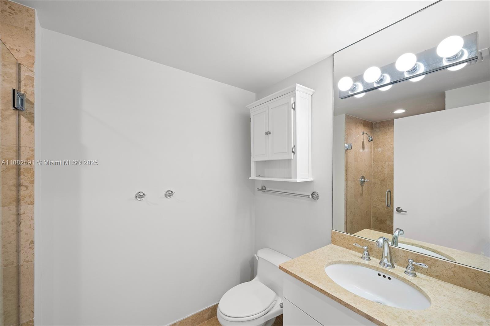 4779 Collins Avenue, Unit 501 Miami Beach, FL 33140 - Photo 17 of 45 a bathroom with a sink vanity mirror and toilet