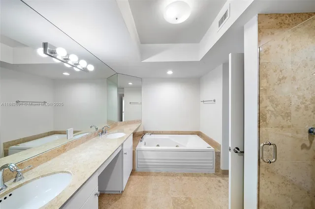 a bathroom with a granite countertop double vanity sink a mirror and a shower