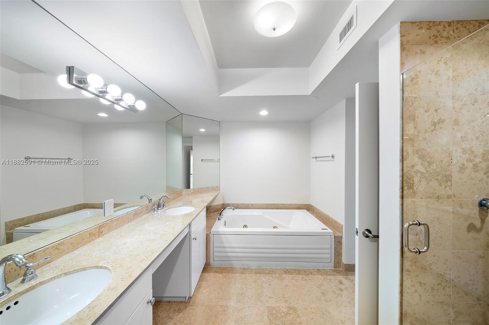4779 Collins Avenue, Unit 501 Miami Beach, FL 33140 - Photo 19 of 45 a bathroom with a granite countertop double vanity sink a mirror and a shower