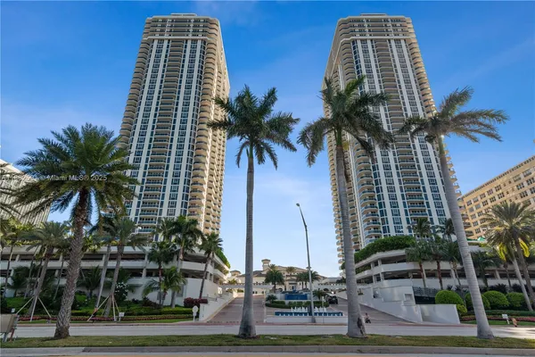 a front view of multi story residential apartment building with a yard