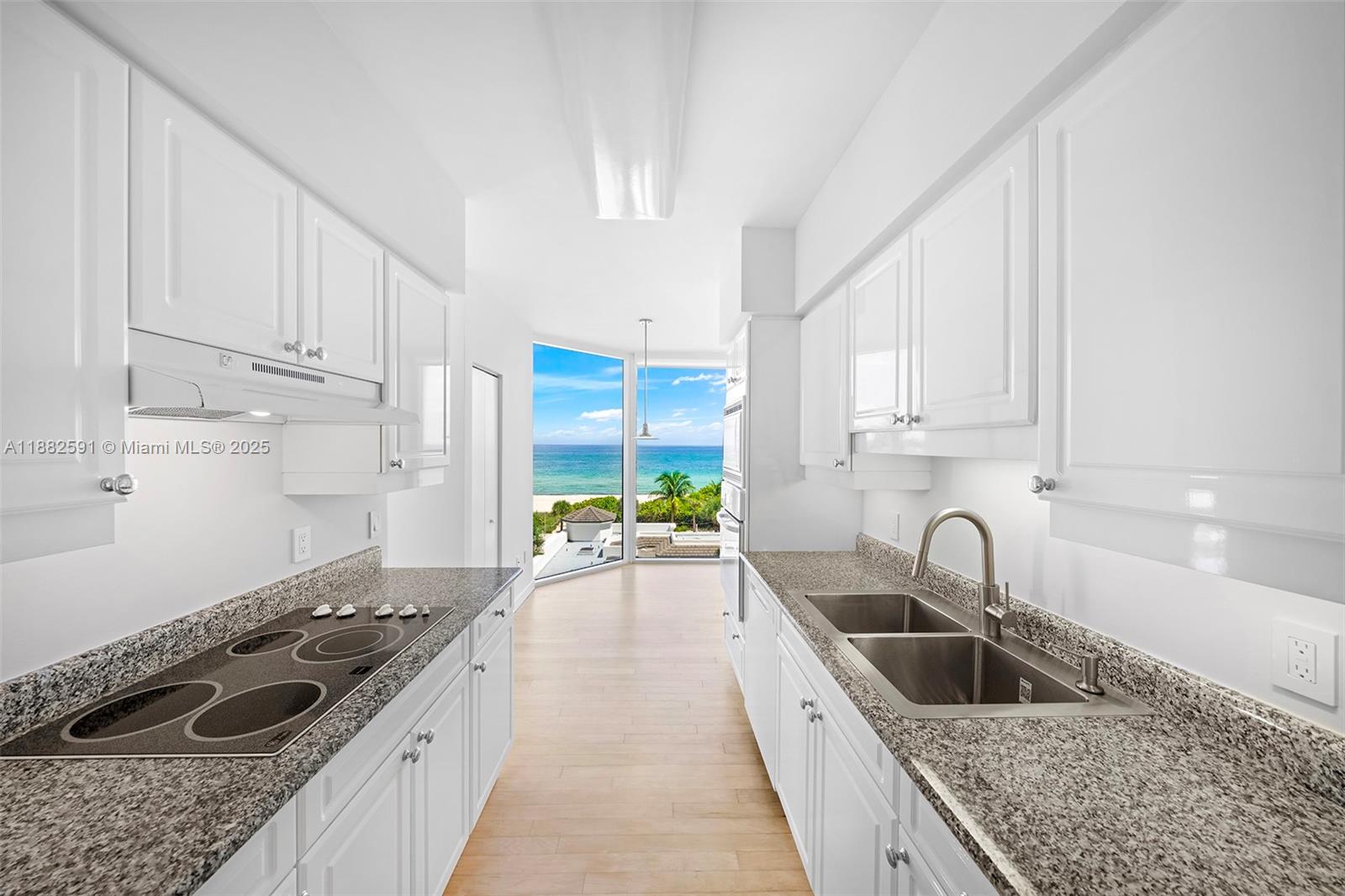 4779 Collins Avenue, Unit 501 Miami Beach, FL 33140 - Photo 8 of 45 a kitchen with a sink stove and cabinets