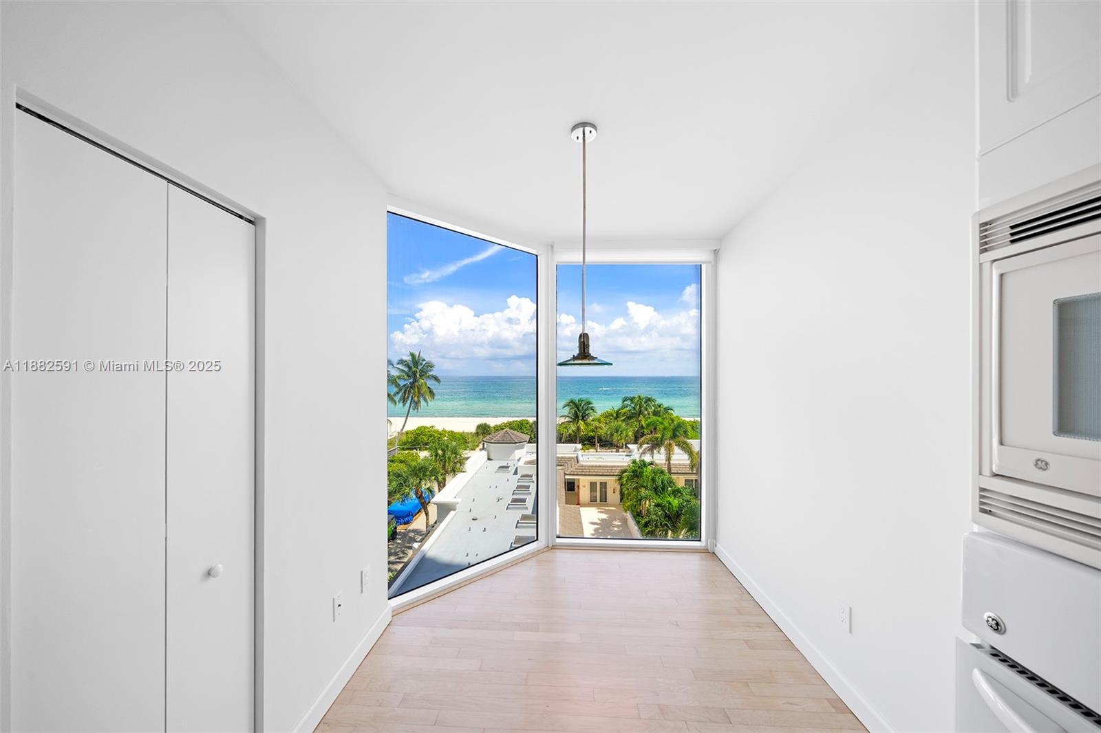 4779 Collins Avenue, Unit 501 Miami Beach, FL 33140 - Photo 10 of 45 a view of a hallway to a room with wooden floor and a cabinet