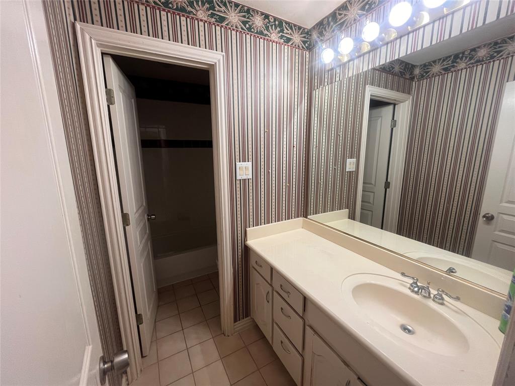 341 Rolling Oaks Ridge Cedar Hill, TX 75104 - Photo 27 of 27 Bathroom with light tile patterned flooring, vanity, wallpapered walls, and shower / washtub combination