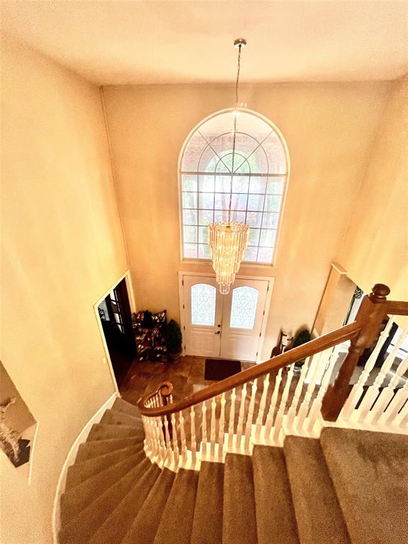 341 Rolling Oaks Ridge Cedar Hill, TX 75104 - Photo 6 of 27 Stairs featuring a chandelier, a high ceiling, and carpet floors