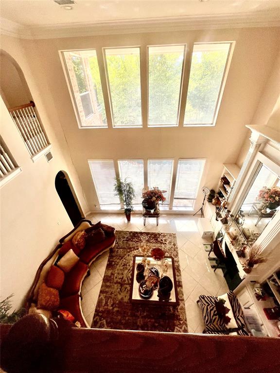 341 Rolling Oaks Ridge Cedar Hill, TX 75104 - Photo 8 of 27 Living room featuring tile patterned floors, ornamental molding, plenty of natural light, and a towering ceiling