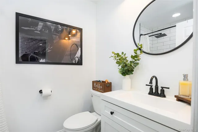 a bathroom with a toilet a sink and mirror