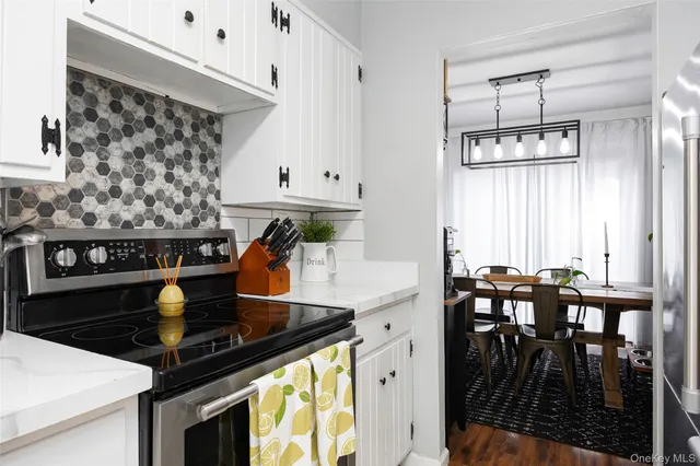 a kitchen with stainless steel appliances a stove a table and chairs
