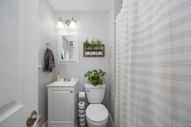 a bathroom with a toilet a sink and mirror