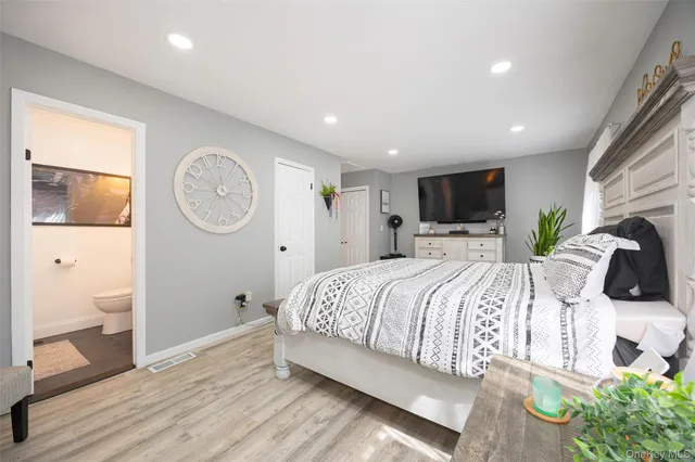 a bedroom with a bed a mirror and a large window