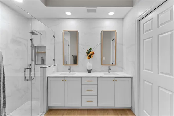 a bathroom with a double vanity sink mirror and shower