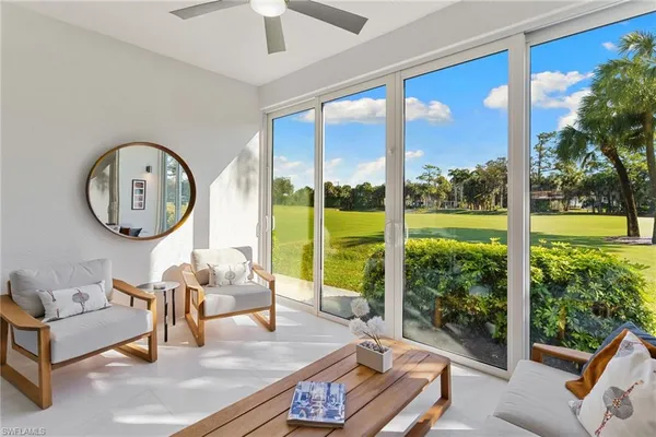 a living room with furniture and a floor to ceiling window