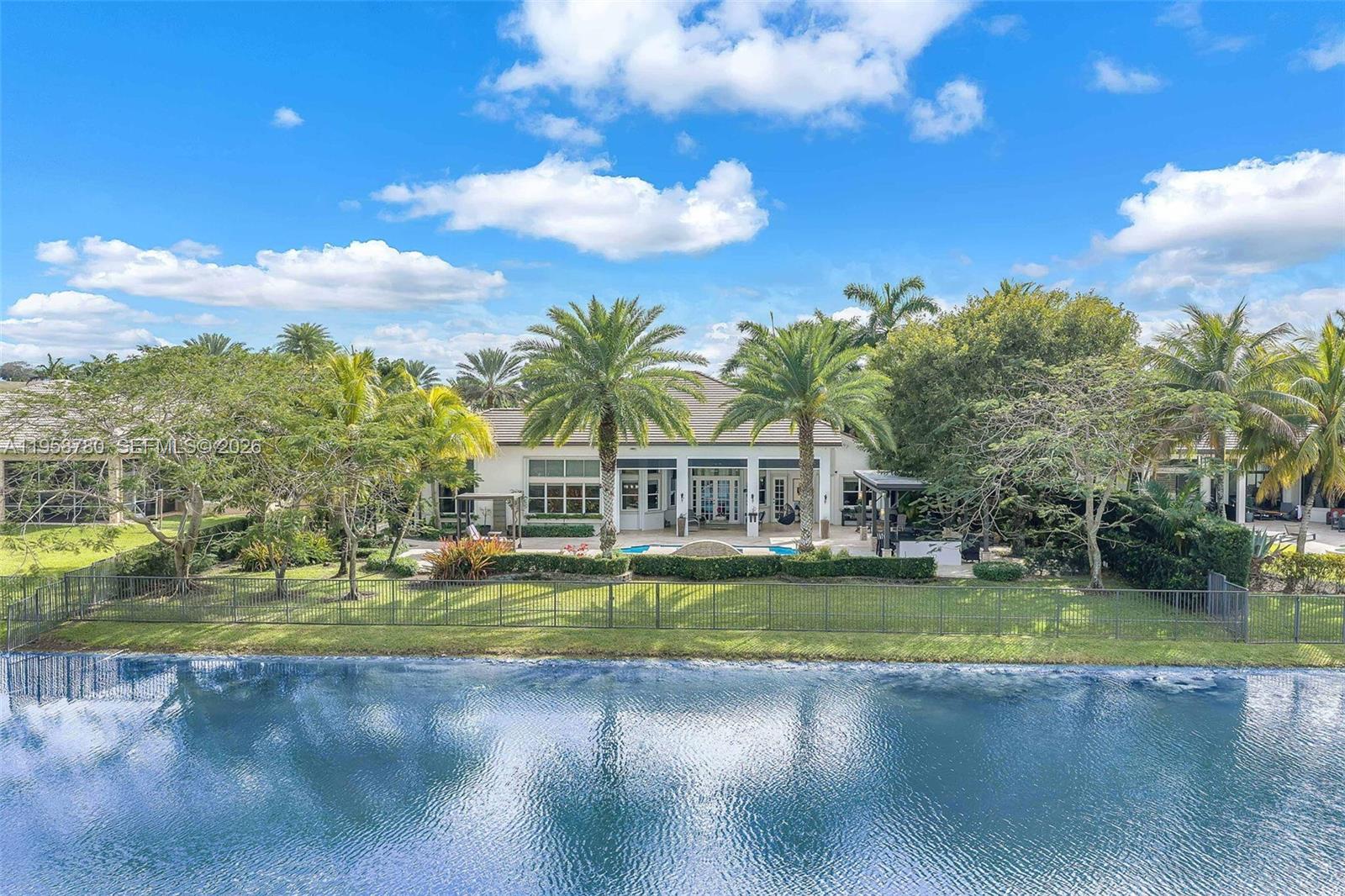 14931 Southwest 38th Street Davie, FL 33331 - Photo 14 of 82 a view of a white house with a big yard and potted plants