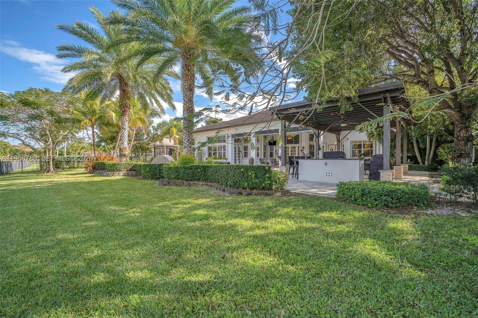 14931 Southwest 38th Street Davie, FL 33331 - Photo 27 of 82 a view of a house with a big yard and palm trees