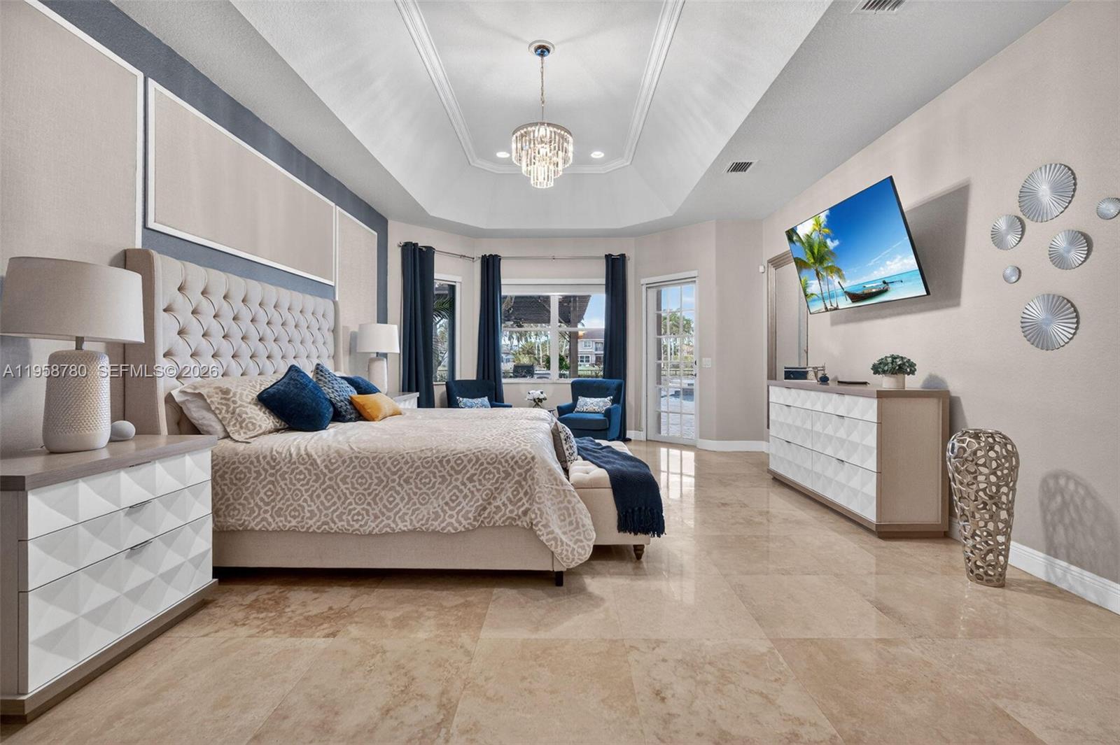 14931 Southwest 38th Street Davie, FL 33331 - Photo 61 of 82 a spacious bedroom with a bed a couch and a flat tv screen on the dresser