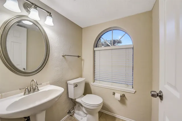 an empty room with chandelier fan and windows