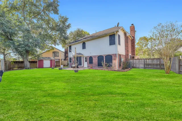 a view of a patio with table and chairs potted plants and large tree