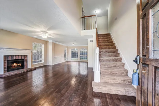 a view of an entryway with wooden floor fireplace and windows