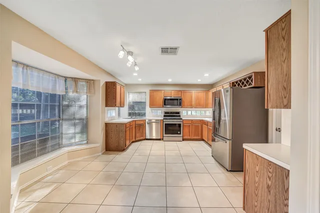 a kitchen with stainless steel appliances granite countertop a refrigerator and a sink