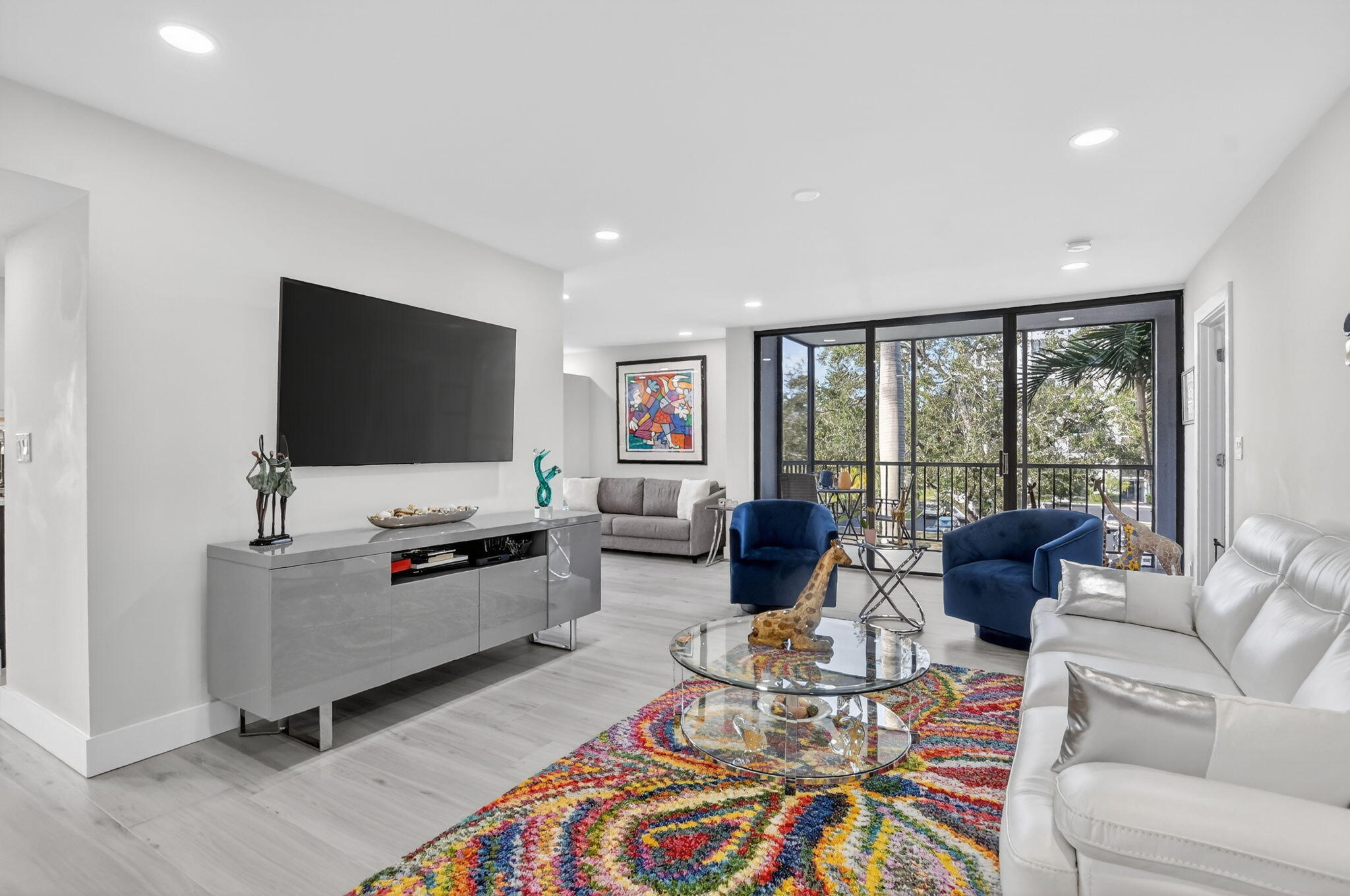 7802 Lakeside Boulevard, Unit 734 Boca Raton, FL 33434 - Photo 2 of 34 a living room with furniture and a flat screen tv