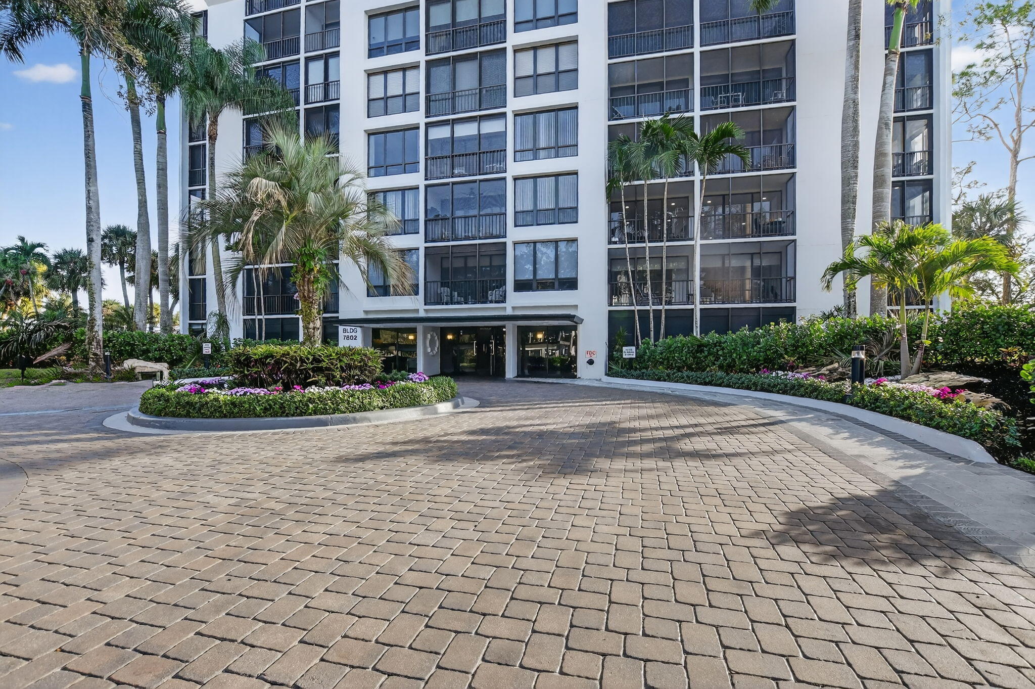 7802 Lakeside Boulevard, Unit 734 Boca Raton, FL 33434 - Photo 31 of 34 a front view of a building with a garden