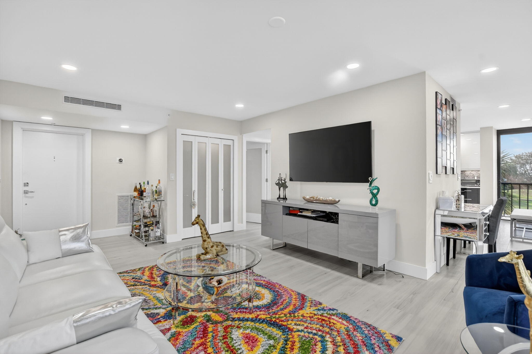 7802 Lakeside Boulevard, Unit 734 Boca Raton, FL 33434 - Photo 5 of 34 a living room with furniture and a flat screen tv