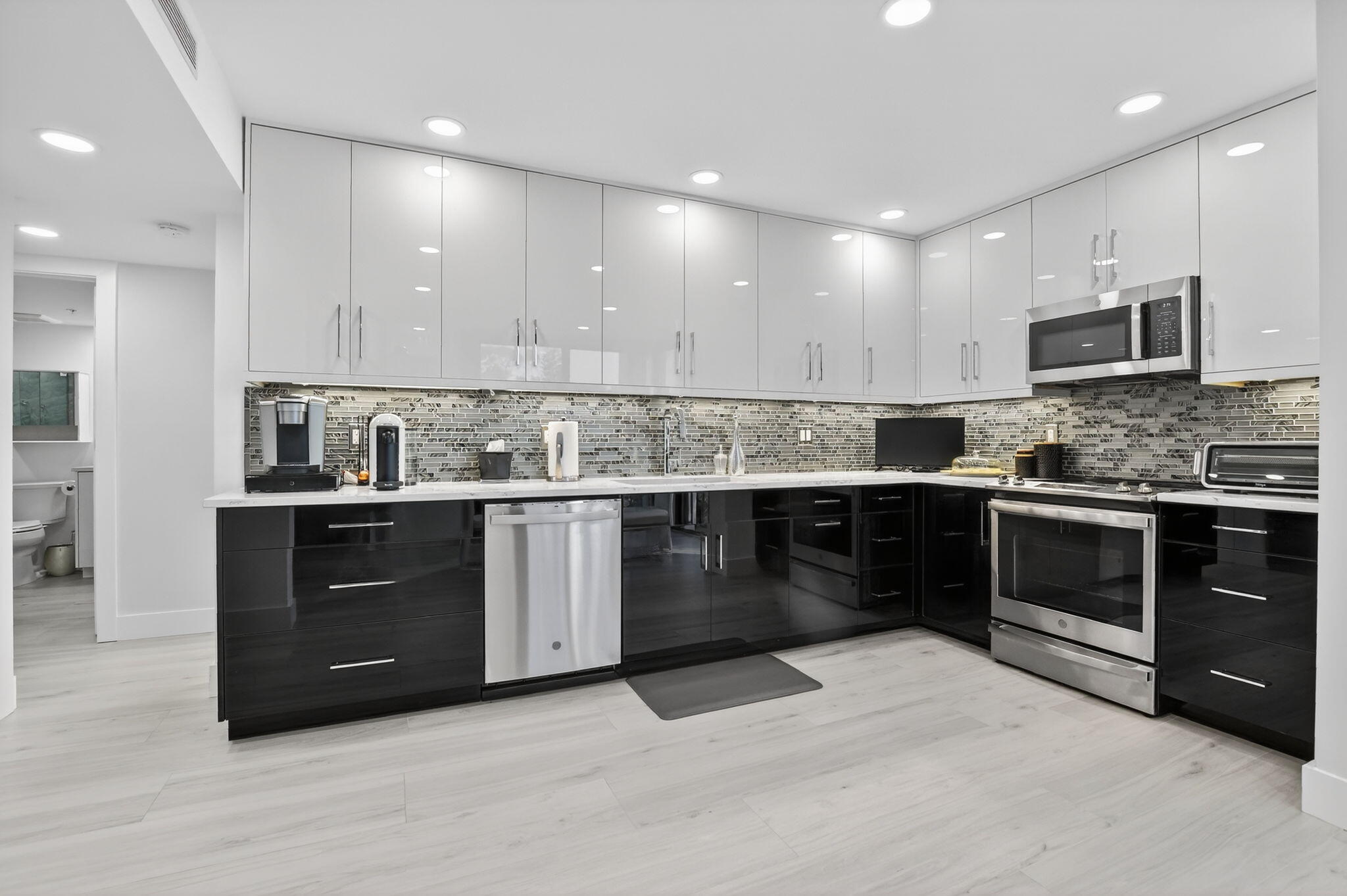 7802 Lakeside Boulevard, Unit 734 Boca Raton, FL 33434 - Photo 9 of 34 a kitchen with kitchen island granite countertop a stove top oven and cabinets