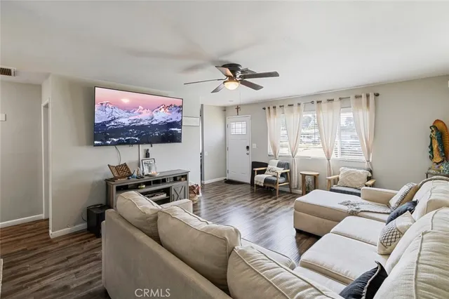 a living room with furniture a flat screen tv and a window