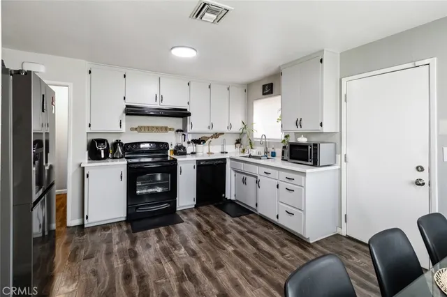 a kitchen with cabinets stainless steel appliances and a window