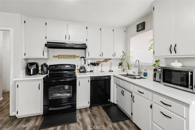a kitchen with stainless steel appliances a stove a sink and white cabinets
