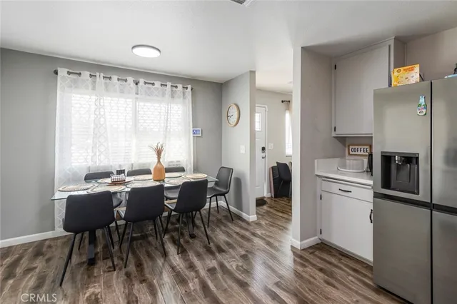 a kitchen with a table chairs refrigerator and cabinets