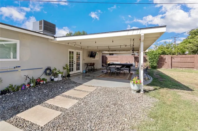 a view of a patio with a dining table and chairs under an umbrella