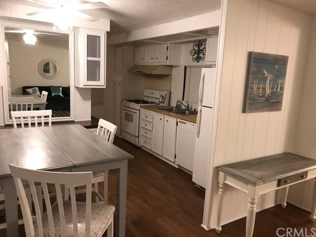 10200 Johnson Road, Unit 44 Phelan, CA 92371 - Photo 6 of 29 a kitchen with stainless steel appliances granite countertop a stove a refrigerator a sink a dining table and chairs