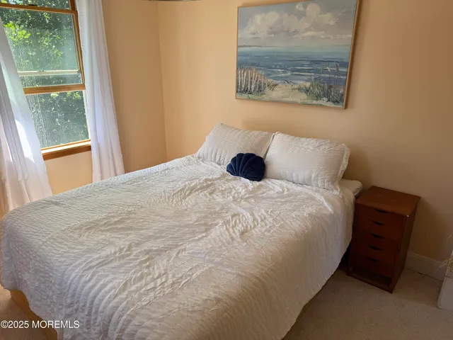 a large bed sitting in a bedroom next to a window