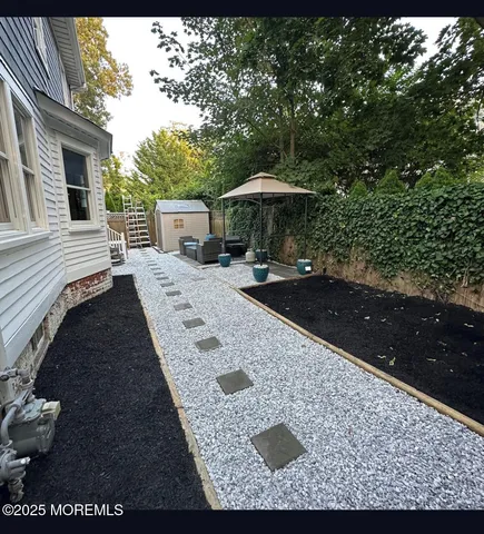 a view of a backyard with chairs and umbrella