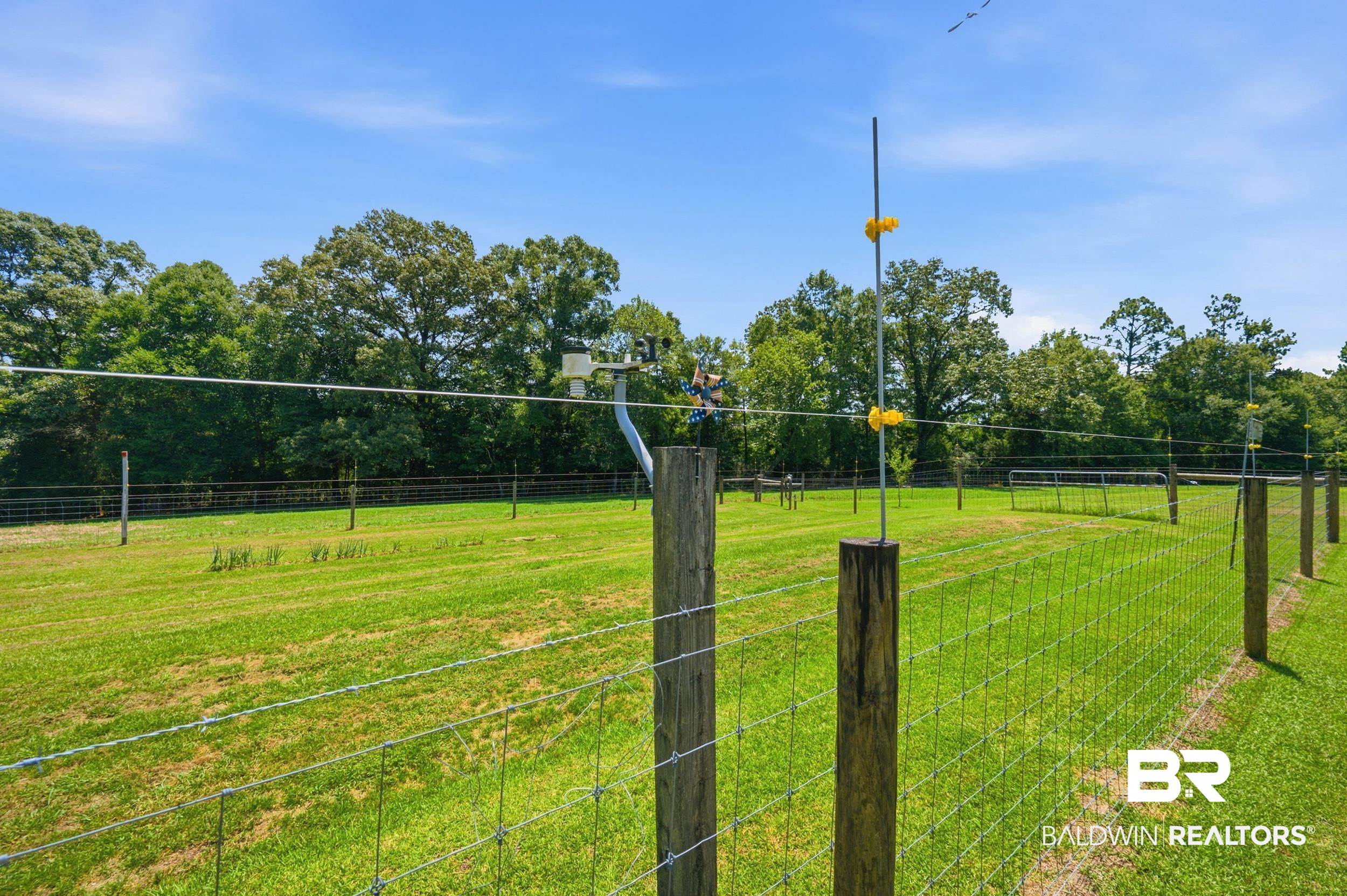 15855 Calvin Richerson Road Bay Minette, AL 36507 - Photo 67 of 83 Expansive grassy field with perimeter fencing, featuring wooden posts and wire mesh