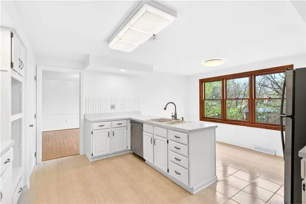 a view of a kitchen with sink wooden floor and windows