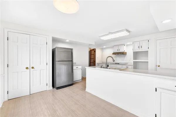 a kitchen with stainless steel appliances granite countertop a refrigerator sink and white cabinets