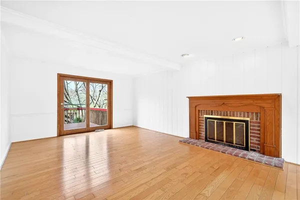 a view of an empty room with a fireplace and a window