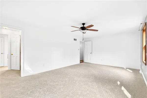 a view of room with a ceiling fan and window