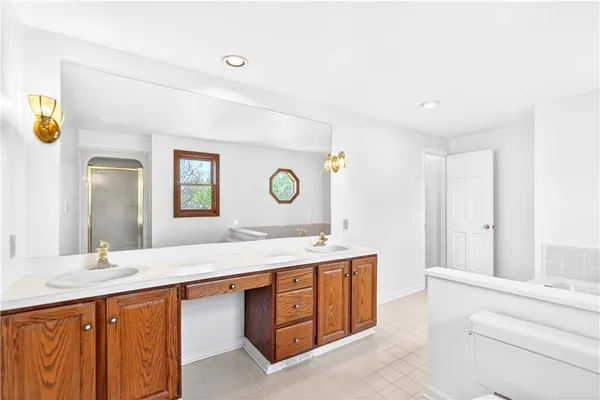 a bathroom with a granite countertop double vanity sink and a mirror
