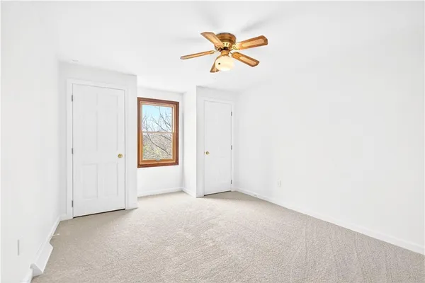 an empty room with a window and a ceiling fan