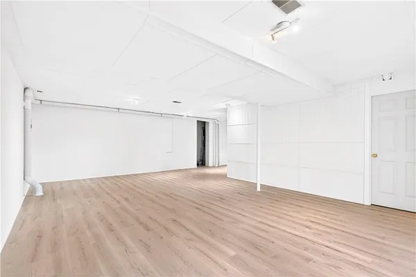 a view of empty room with wooden floor
