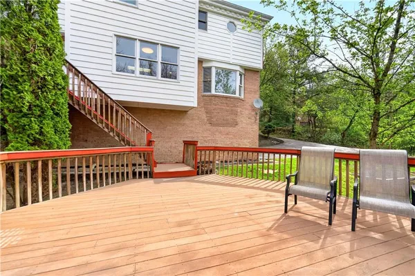 a balcony with wooden floor and outdoor seating