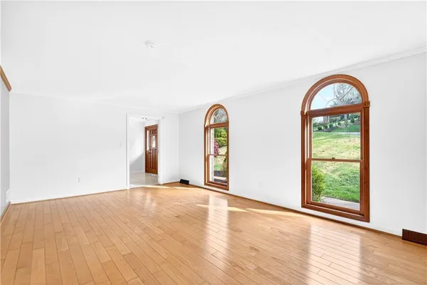 a view of a livingroom with wooden floor and a window