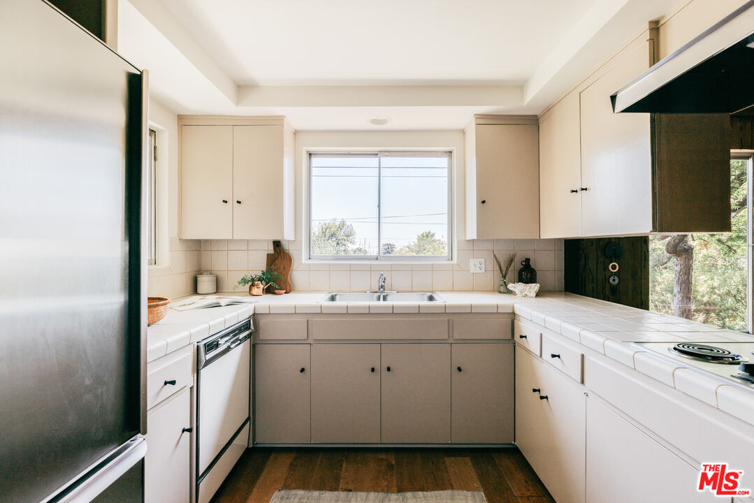 580 Cocopan Drive Altadena, CA 91001 - Photo 12 of 29 a kitchen with white cabinets appliances a sink and a window
