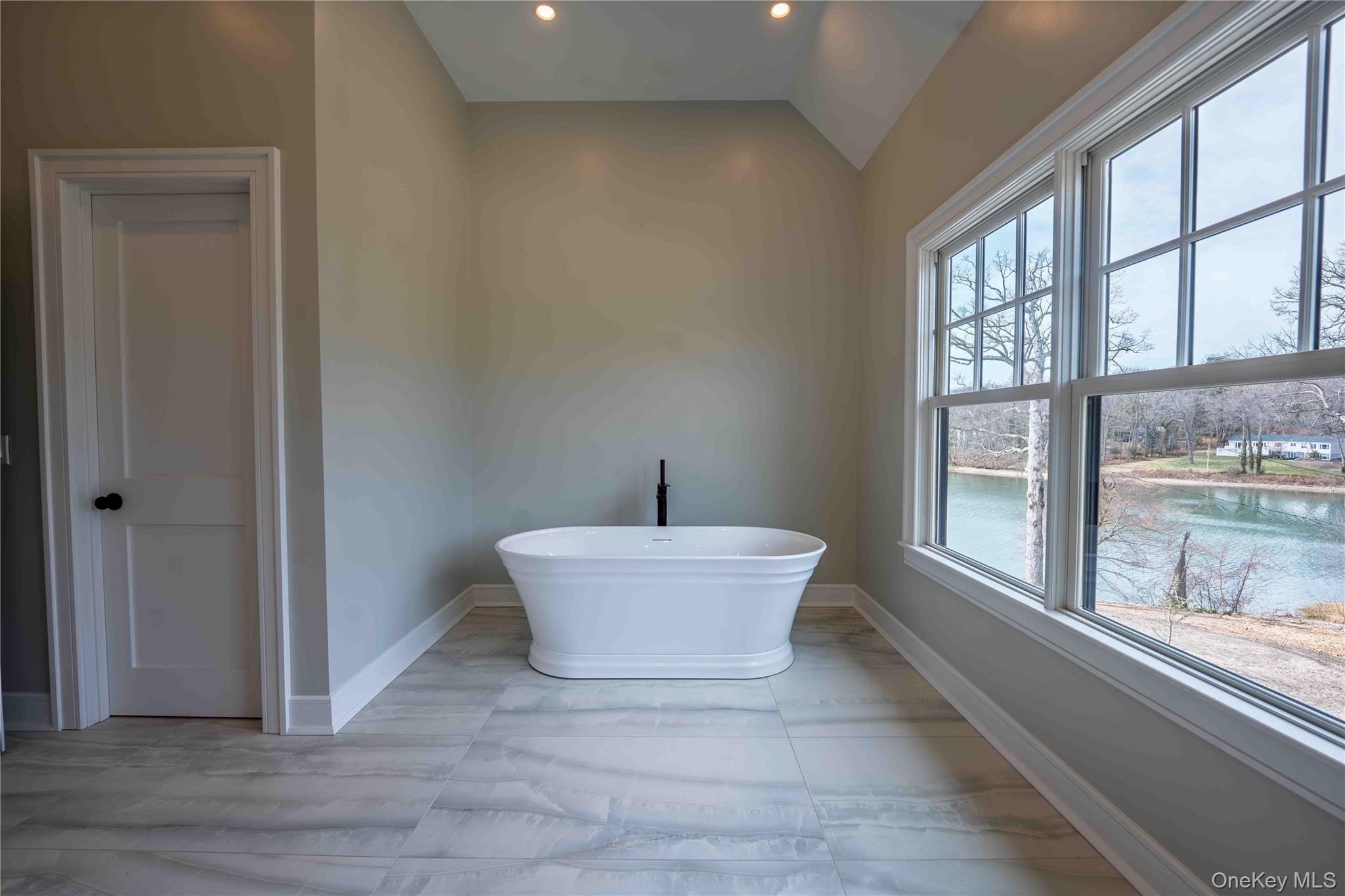 106 Cove Road Asharoken, NY 11768 - Photo 26 of 46 Full bath featuring a freestanding tub, lofted ceiling, recessed lighting, and a water view