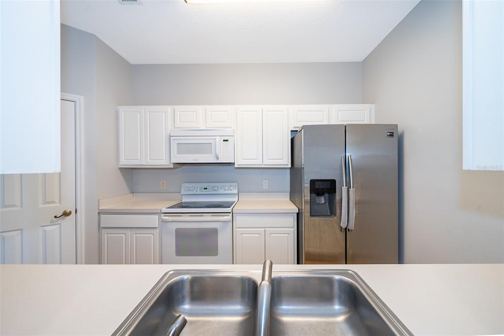 581 Brantley Terrace Way, Unit 202 Altamonte Springs, FL 32714 - Photo 12 of 25 a kitchen with a refrigerator sink and cabinets