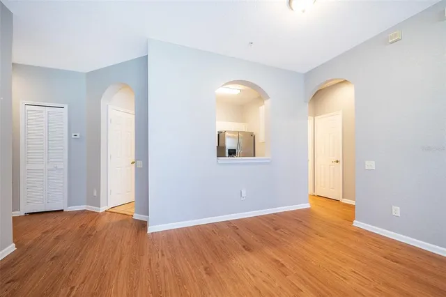 a view of empty room with wooden floor and window