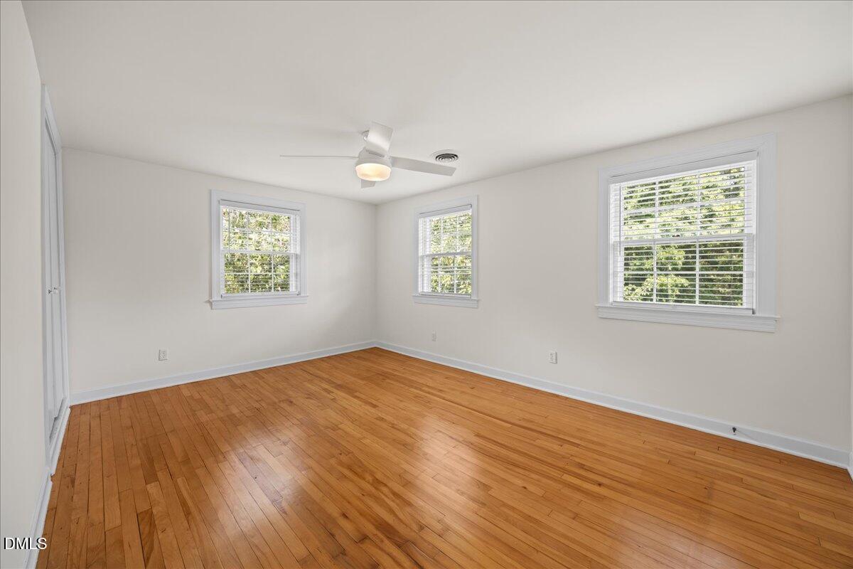 1627 Sutton Drive Raleigh, NC 27605 - Photo 16 of 33 a view of an empty room with wooden floor and a window