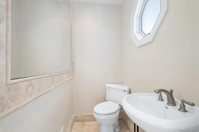 a bathroom with a toilet sink and mirror